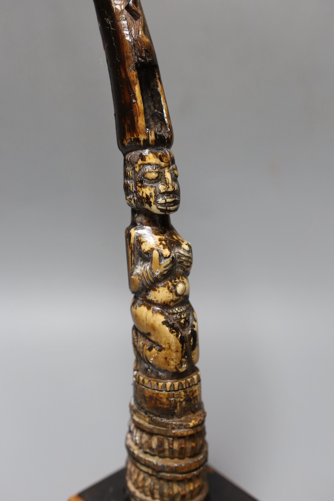 An African carved ivory divination tapper, probably Yoruba tribe on stand, 35 cms high.